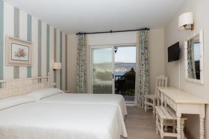 1 dormitorio con 2 camas y ventana en Villa Covelo, en Poio