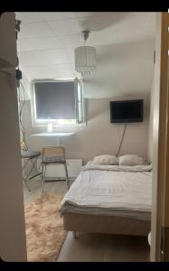 une chambre avec un lit, une fenêtre et une chaise dans l'établissement Yksiö lähellä Kupittaa Rautatieasemaa Turku, à Turku