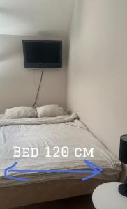 une chambre avec un lit avec une télévision au mur dans l'établissement Yksiö lähellä Kupittaa Rautatieasemaa Turku, à Turku