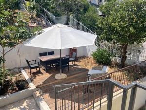 a wooden deck with a table and an umbrella at Mediteraneo in Dubrovnik