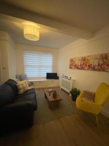 - un salon avec un canapé et une table dans l'établissement West End one-bedroom flat Witney, Oxfordshire, à Witney
