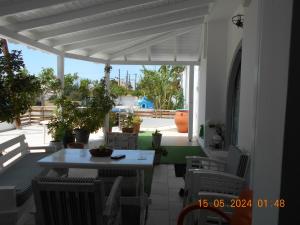 a white patio with a table and chairs on a balcony at Garifalia Studios in Kalamaki Heraklion