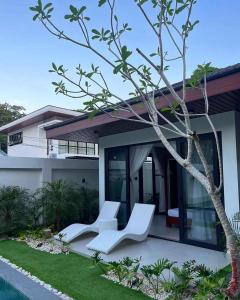 two white chairs sitting in front of a house at Villa Anela in Puerto Princesa City