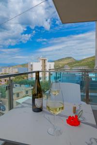 una botella de vino y una copa en una mesa en Heksamil Hotel, en Ksamil