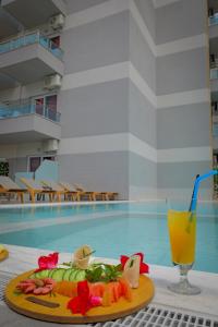 un plato de comida y una bebida junto a una piscina en Heksamil Hotel, en Ksamil