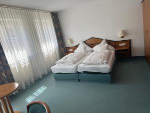 Habitación de hotel con 2 camas y almohadas blancas en ST Hotel en Reichertshofen