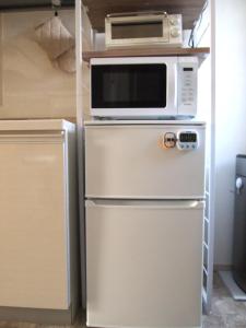 eine Mikrowelle auf einem Kühlschrank in der Küche in der Unterkunft Minpaku 123 - Vacation STAY 15837 in Nasushiobara