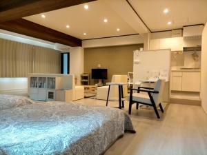 1 dormitorio con cama, escritorio y cocina en Minpaku 123 - Vacation STAY 15837, en Nasushiobara