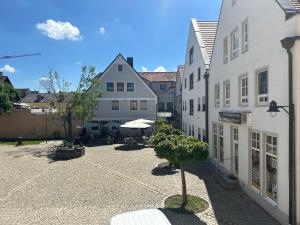 an empty courtyard in a town with white buildings at ST Hotel in Reichertshofen