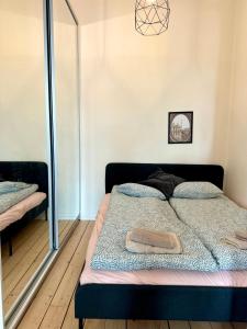 een slaapkamer met een bed met een spiegel en een spiegel bij Melrose Place in Helsinki