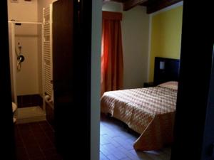 a room with a bedroom with a bed and a bathroom at AgriHotel Papaya in San Pietro Apostolo