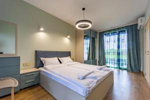a bedroom with a large bed and a window at City Center Apartments in Kŭrdzhali