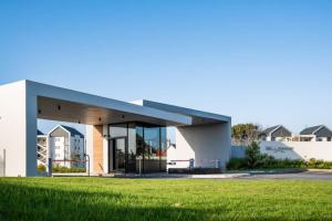 a building with a grass field in front of it at Summerstrand Escape Bella Mare in Gqeberha