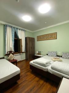 1 dormitorio con 2 camas y suelo de madera en OLD CITADEL with Terace, en Bukhara