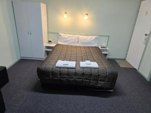 1 dormitorio con 1 cama con 2 toallas en Lake Forbes Motel, en Forbes