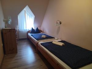 2 camas individuales en una habitación con ventana en Diána Fogadó en Keszthely