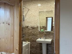 La salle de bains est pourvue d'un lavabo et d'un miroir. dans l'établissement Kirch Hotel & Restaurant, à Goris