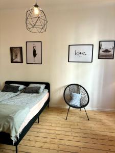 een slaapkamer met een bed en een stoel erin bij Melrose Place in Helsinki +1 foto