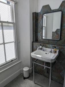 a bathroom with a sink and a mirror at The Chelsea in Llandudno