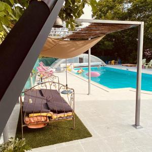 a metal chair sitting next to a swimming pool at Le Mas des Papillons in Fargues