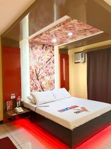 uma cama num quarto com uma pintura na parede em Hotel Sogo Sta Rosa em Santa Rosa