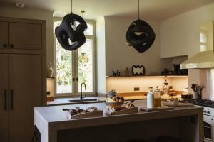 Una cocina con donas negras colgando del techo. en Maison de Magescq, en Magescq