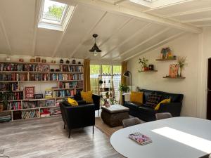 ein Wohnzimmer mit vielen Bücherregalen in der Unterkunft Chalet de kleine Eekhoorn in Lage Mierde