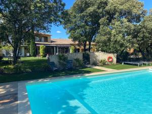 - une piscine en face d'une maison dans l'établissement Logis La Bastide De Grignan Hotel & Restaurant "La Chênaie", à Grignan