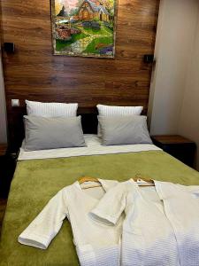 ein Schlafzimmer mit 2 Betten und weißen Kleidern darauf in der Unterkunft Исы Байзакова 133 in Pawlodar