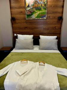 ein Bett mit zwei weißen Klamotten darüber in der Unterkunft Исы Байзакова 133 in Pawlodar