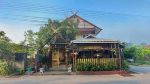 uma pequena casa com uma cerca em frente em Baan Baramee House em Chiang Rai