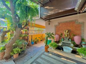 Baan Baramee House في شيانج راي: غرفة بها مجموعة من النباتات ومدفأة