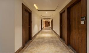 a long hallway with doors and a long hallwayngth at Treebo Trend Eden Park, Ahmedabad in Ahmedabad
