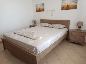 a bed in a bedroom with two night stands and two lamps at ANATOLI ROOMS SERIFOS in Serifos Chora