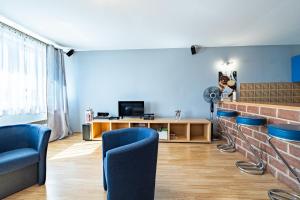 シュチェチンにあるApartament MonteCassinoの青い壁のリビングルーム(青い椅子付)