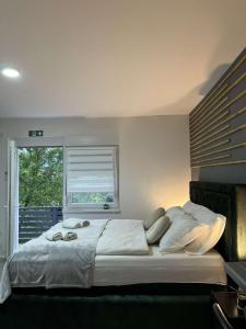 Una cama grande en un dormitorio con ventana. en Apartments Indigo, en Jajce