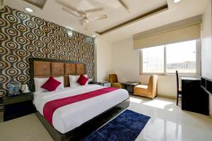 um quarto com uma cama grande e almofadas vermelhas em The EL DE Belwood Hotel By Delhi Airport em Nova Deli