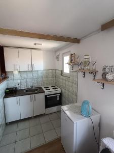 una cucina con armadietti bianchi e frigorifero bianco di Apartman Biser a Sarajevo