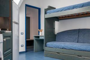 sypialnia z łóżkiem piętrowym i kuchnia w obiekcie Oasi Azzurra w mieście San Saba