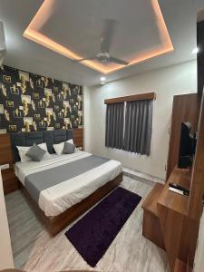 ein Schlafzimmer mit einem großen Bett und einem TV in der Unterkunft Hotel Hill View in Gandhinagar