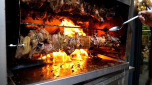 een persoon is vlees aan het koken op een grill bij Villa Emma in Nago-Torbole