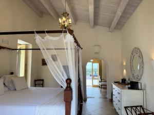 a bedroom with a bed and a chandelier at Terre Di Vendicari in Noto