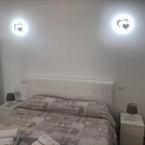 ein Schlafzimmer mit einem Bett und zwei Lampen an der Wand in der Unterkunft Il cuore di Martina in Martina Franca