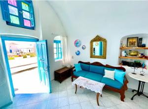 a living room with a blue couch and a table at Sunset Queen in Oia in Oia