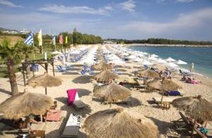 a beach with many umbrellas and chairs and the ocean at Studio47 in Athens