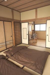 Cama grande en habitación con mesa en Aioi Yanto 一日一組限定古民家宿, en Otaru