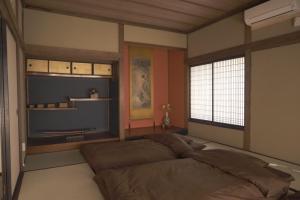 Un dormitorio con una cama grande y una ventana en Aioi Yanto 一日一組限定古民家宿, en Otaru