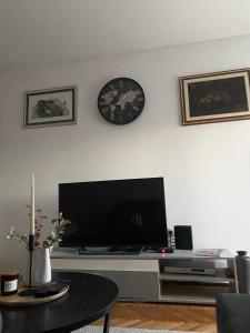 a living room with a tv and a clock on the wall at Apartment Niko in Split