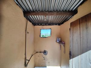 a bathroom with a metal ceiling and a window at Simoonga Thandizani School in Livingstone