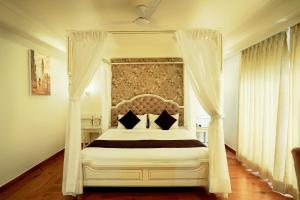 una camera da letto con letto a baldacchino bianco e cuscini neri di Hotel Magenta Jaipur a Jaipur